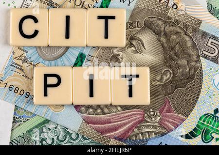Die Formulierung „PIT“ und „CIT“ wurde mit „Personal Income Tax“ und „Company Income Tax“ sowie vielen polnischen Banknoten übersetzt. Neue Steuervorschriften in Polen ab 2022. Stockfoto