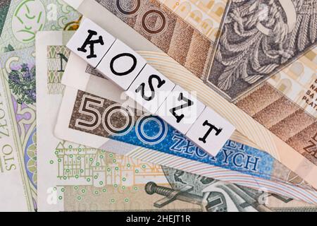 Der Wortlaut „Arzt“ wurde mit „Kosten“ und vielen polnischen Banknoten übersetzt. Neue Steuervorschriften in Polen. Foto aufgenommen unter künstlichem, weichem Licht Stockfoto