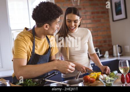 Glückliches junges biracial Paar Kochen Mahlzeit zusammen in der Küche zu Hause Stockfoto