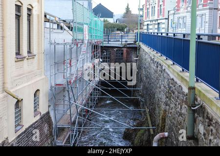 Hagen, Deutschland. 11th Januar 2022. Ein halbes Jahr nach dem Hochwasserschaden an einem Gebäude stehen Gerüste an der einstürzenden Wand. Mitte Juli 2021 verursachten heftige Regenfälle und Stürme vielerorts Überschwemmungen und Zerstörungen. In Nordrhein-Westfalen war Hagen besonders stark betroffen. Hänge rutschten hinunter, überflutete Straßen wurden gesperrt. Quelle: Alex Talash/dpa/Alamy Live News Stockfoto