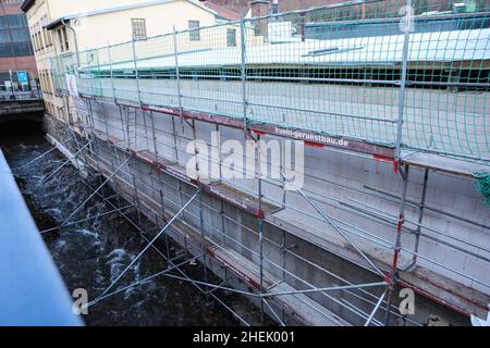 Hagen, Deutschland. 11th Januar 2022. Ein halbes Jahr nach dem Hochwasserschaden an einem Gebäude stehen Gerüste an der einstürzenden Wand. Mitte Juli 2021 verursachten heftige Regenfälle und Stürme vielerorts Überschwemmungen und Zerstörungen. In Nordrhein-Westfalen war Hagen besonders stark betroffen. Hänge rutschten hinunter, überflutete Straßen wurden gesperrt. Quelle: Alex Talash/dpa/Alamy Live News Stockfoto