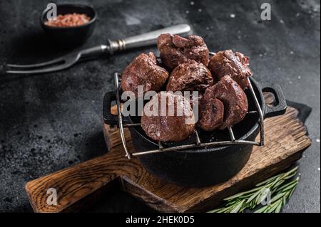 Gegrillte Rinderkidney, Schlachtnebenfleisch auf dem Grill. Schwarzer Hintergrund. Draufsicht Stockfoto