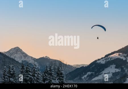 Paragliding Sonnenuntergang über den verschneiten Bergen Stockfoto