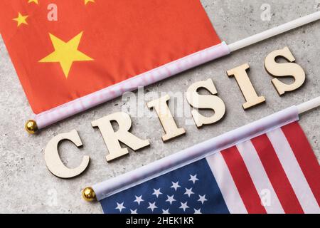 Text aus Holzbuchstaben und zwei Flaggen, das Konzept der Krise in den Beziehungen zwischen China und Amerika Stockfoto