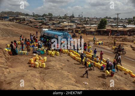 Nairobi, Kenia. 11th Januar 2022. Die Bewohner stehen während der kostenlosen kommunalen Wasserdienste, die von den Nairobi Metropolitan Services (N.M.S) in den Slums von Kibera in Nairobi bereitgestellt werden, in der Schlange. Die meisten Einwohner von Nairobi erleben weiterhin den täglichen Mangel und den Mangel an Wasser. In den Slums von Kibera haben die Nairobi Metropolitan Services (N.M.S) die Verantwortung übernommen, den meisten Bewohnern in einigen armen Gemeinden den Zugang zu kostenlosen und häufigen Trinkwasserdiensten zu ermöglichen. (Bild: © Donwilson Odhiambo/ZUMA Press Wire) Stockfoto