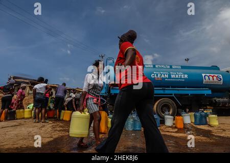 Nairobi, Kenia. 11th Januar 2022. Die Bewohner stehen während der kostenlosen kommunalen Wasserdienste, die von den Nairobi Metropolitan Services (N.M.S) in den Slums von Kibera in Nairobi bereitgestellt werden, in der Schlange. Die meisten Einwohner von Nairobi erleben weiterhin den täglichen Mangel und den Mangel an Wasser. In den Slums von Kibera haben die Nairobi Metropolitan Services (N.M.S) die Verantwortung übernommen, den meisten Bewohnern in einigen armen Gemeinden den Zugang zu kostenlosen und häufigen Trinkwasserdiensten zu ermöglichen. (Bild: © Donwilson Odhiambo/ZUMA Press Wire) Stockfoto