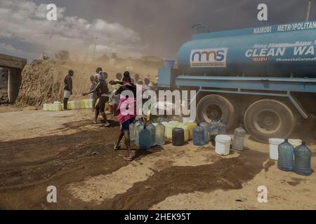 Nairobi, Kenia. 11th Januar 2022. Die Bewohner stehen während der kostenlosen kommunalen Wasserdienste, die von den Nairobi Metropolitan Services (N.M.S) in den Slums von Kibera in Nairobi bereitgestellt werden, in der Schlange. Die meisten Einwohner von Nairobi erleben weiterhin den täglichen Mangel und den Mangel an Wasser. In den Slums von Kibera haben die Nairobi Metropolitan Services (N.M.S) die Verantwortung übernommen, den meisten Bewohnern in einigen armen Gemeinden den Zugang zu kostenlosen und häufigen Trinkwasserdiensten zu ermöglichen. (Bild: © Donwilson Odhiambo/ZUMA Press Wire) Stockfoto