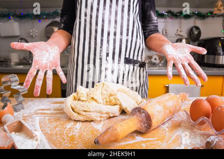 Eine unerfahrene Hausfrau, eine Köchin, weiß nicht, wie man den Teig richtig knetet, bittet um Rat. Schlechtes Kochkonzept, Unerfahrensein. Stockfoto