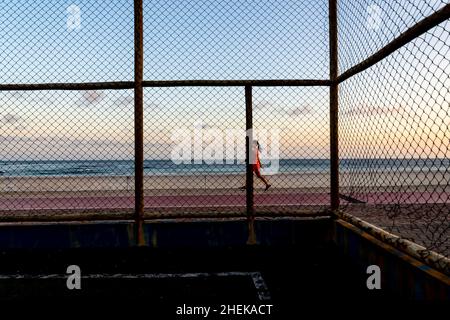 Menschen, die am Strand von Paciencia in Rio Vermelho in Salvador, Brasilien, entlang gehen. Stockfoto