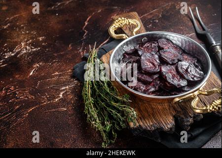 Hausgemachte Wildwurst.mit Kräutern in einer Pfanne. Dunkler Hintergrund. Draufsicht. Speicherplatz kopieren Stockfoto
