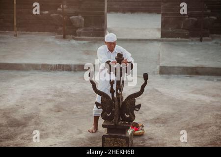 Bali - Indonesien - 10.21.2015: Alter balinesischer - indonesischer Mann zündet das Feuer für den traditionellen Kecak-Feuertanz, der im Pura Luhur stattfindet Stockfoto