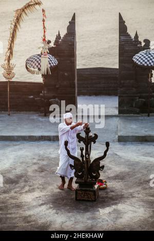 Bali - Indonesien - 10.21.2015: Alter balinesischer - indonesischer Mann zündet das Feuer für den traditionellen Kecak-Feuertanz, der im Pura Luhur stattfindet Stockfoto