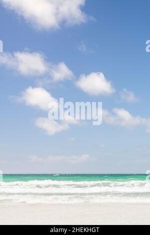 Meereslandschaft mit Blick auf türkisfarbenes Wasser und weiße Wellen am Strand. Mit blauem Himmel und weißen, flauschigen Wolken. Berneray Waves no1. Stockfoto