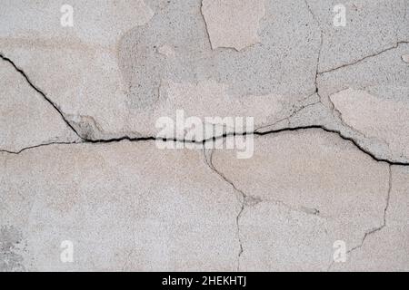 Nahaufnahme von rissiger Betonwand. Alte Wand mit altem Putz. Strukturierter Hintergrund Stockfoto
