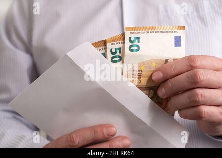 EURO-Banknoten bar. Der Mann nimmt aus dem Umschlag eu-Bargeld. Nahaufnahme Stockfoto