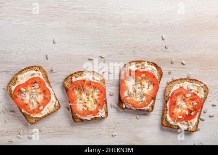 Toast mit Frischkäse, Pfeffer, Mikrogemüse und Sonnenblumenkernen Stockfoto