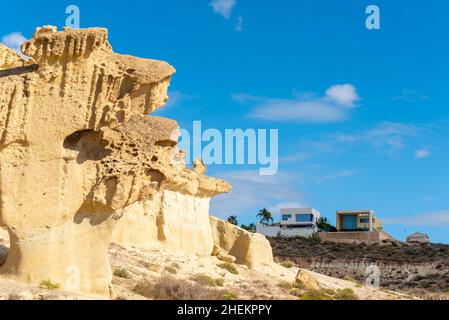 Las Gredas de Bolnuevo, auch Ciudad Encantada genannt, sind stark erodierte Sandsteinformationen am Strand von Bolnuevo, Murcia, Spanien. Häuser Stockfoto