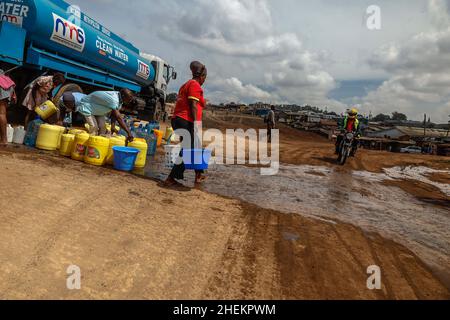 Nairobi, Kenia. 11th Januar 2022. Während der Wasserknappheit sahen die Anwohner, wie sie ihre Wasserkanister füllten.die meisten Bewohner Nairobis erleben weiterhin den täglichen Mangel und den Mangel an Wasser. In den Slums von Kibera haben die Nairobi Metropolitan Services (N.M.S) die Verantwortung übernommen, den meisten Bewohnern in einigen armen Gemeinden den Zugang zu kostenlosen und häufigen Trinkwasserdiensten zu ermöglichen. Kredit: SOPA Images Limited/Alamy Live Nachrichten Stockfoto