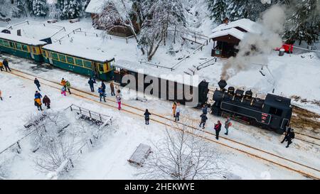 Blick von oben auf einen touristischen Bahnhof in Maramures County, Rumänien, Aufnahme aus einer niedrigen Höhe in der Wintersaison. Stockfoto
