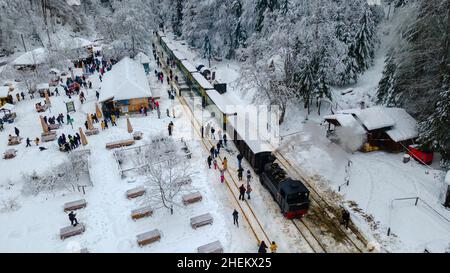 Blick von oben auf einen touristischen Bahnhof in Maramures County, Rumänien, Aufnahme aus einer niedrigen Höhe in der Wintersaison. Stockfoto
