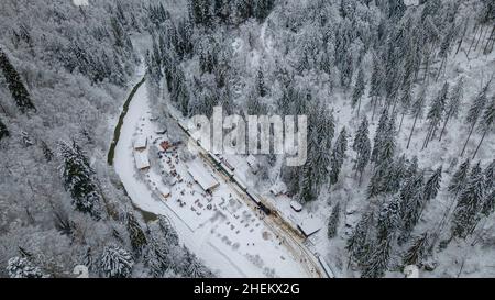 Blick von oben auf einen touristischen Bahnhof im Landkreis Maramures, Rumänien, Aufnahme aus einer hohen Höhe in der Wintersaison. Stockfoto
