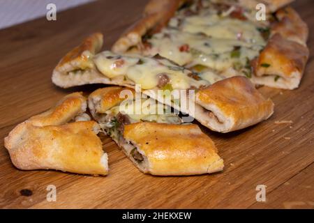 Türkische Pita mit Rindfleisch und Käse. Türkisches Pide mit Fleischkäse und Gemüse auf einem hölzernen Hintergrund Stockfoto