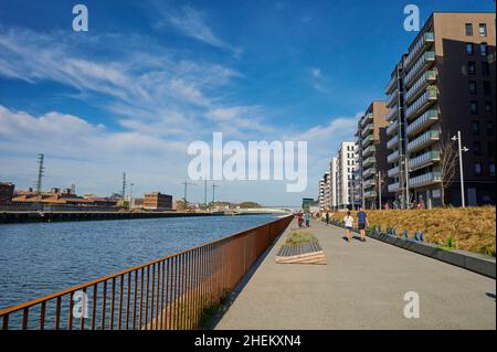 Menschen, die an einem sonnigen Wintertag am Ufer des Flusses Nervión spazieren Stockfoto