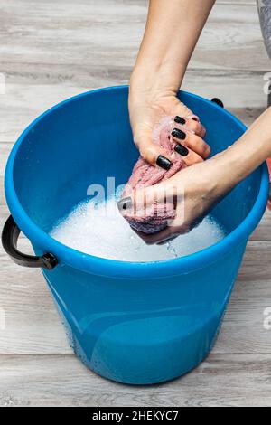 Frau wringen einen Lappen in einen Eimer mit Wasser während der Reinigung. Hochwertige Fotos Stockfoto