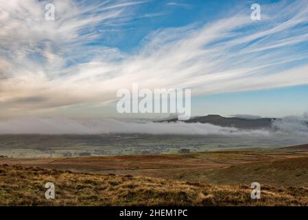 Ein Wanderer, der einen großen Rucksack trägt, steigt von einem Wandstile am Fuße des letzten Aufstiegs zum Gipfel von Pen-y-Ghent in North Yorkshire herab Stockfoto