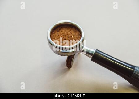 Portafilter mit gemahlenem Kaffee auf hellgrauem Hintergrund. Draufsicht. Stockfoto