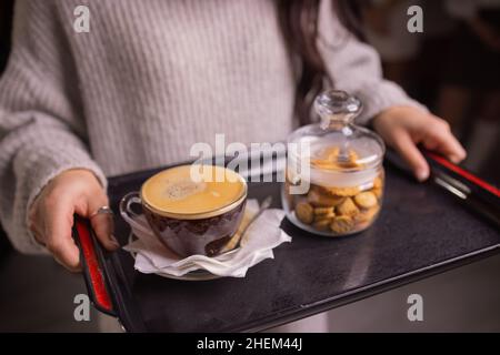 Tassen Kaffee mit Cookies weibliche Hände Nahaufnahme Stockfoto