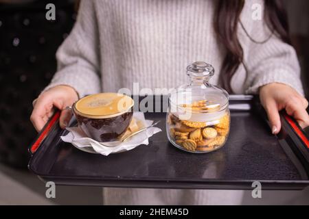 Tassen Kaffee mit Cookies weibliche Hände Nahaufnahme Stockfoto