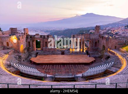 Sonnenuntergang auf dem antiken römisch-griechischen Amphitheater mit der Giardini Naxos Bucht im Hintergrund in Taormina, Sizilien, Italien Stockfoto