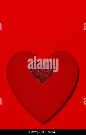St. Valentinstag minimalistische Grußkarte, mit Glitzer und bemalten roten Herzen auf rotem Hintergrund, flaches Lay Stockfoto