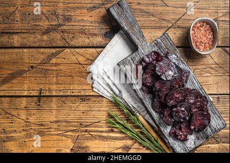 Wildfleischwurst mit Rosmarin auf einem Schneidebrett. Holzhintergrund. Draufsicht. Speicherplatz kopieren Stockfoto