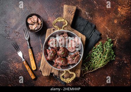 Geröstete Rinderniere, Schlachtnebenfleisch in Pfanne mit Kräutern. Dunkler Hintergrund. Draufsicht Stockfoto