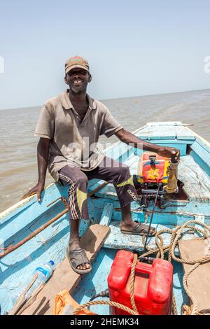 Mann segelt in einem Außenbordmotorkanu auf dem Gambia River in der Nähe von James Island Stockfoto