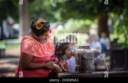 Salta, Argentinien. 19th. Juni 2012. Eine Frau hilft einem Mädchen an einem Brunnen, wenn die Temperaturen in der nördlichen Provinz über 30 Grad steigen. Inmitten der intensiven Hitzewelle ist der Strom an zahlreichen Orten im Großraum Buenos Aires ausgegangen. Kredit: Javier Corbalan/dpa/Alamy Live Nachrichten Stockfoto