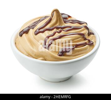 Schüssel mit geschlagenem Karamell und Kaffeesahne mit geschmolzener Schokoladensauce auf weißem Hintergrund isoliert dekoriert Stockfoto