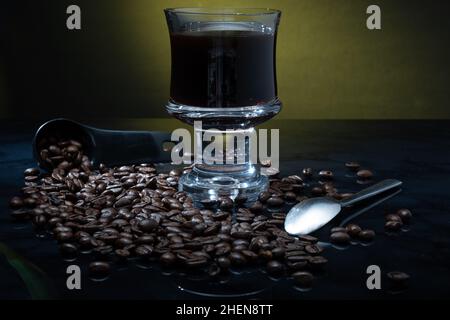 Helsinki / Finnland - 11. JANUAR 2022: Eine Tasse frischen Kaffees umgeben von Kaffeebohnen vor dunklem Hintergrund. Stockfoto