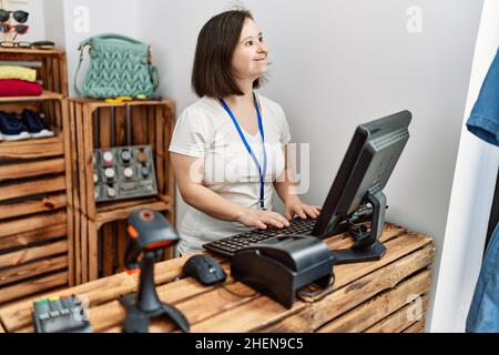 Brünette Frau mit Down-Syndrom lächelnd arbeitet als Verkäuferin im Einzelhandel Stockfoto