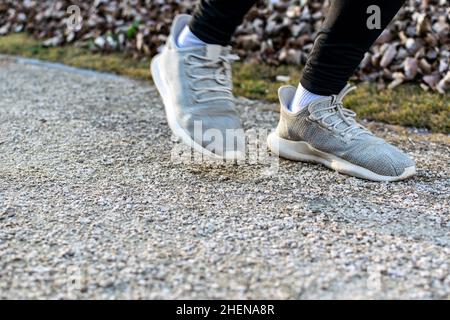 Nicht erkennbare Nahaufnahme der Füße eines jungen Mannes, der im Park joggt Stockfoto