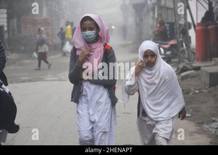 Lahore. Pakistan, 11/10/2022, pakistanische Bürger, Studenten unterwegs während eines kalten und dichten nebligen Morgens in Lahore. Pakistanische Bewohner und Pendler sind aufgrund der plötzlichen Schicht dichten Smogs, die Probleme bei der Atmung, der Sicht verursacht und auch den reibungslosen Verkehrsfluss behindert, mehr besorgt als überrascht. Die Bewohner von Lahore erwachten am Donnerstag zu einer dichten Smogdecke auf, die die Sicht der Pendler verringerte und mehrere Beschwerden über Atembeschwerden und psychische Qualen auflöste. (Foto von Rana Sajid Hussain/Pacific Press) Stockfoto