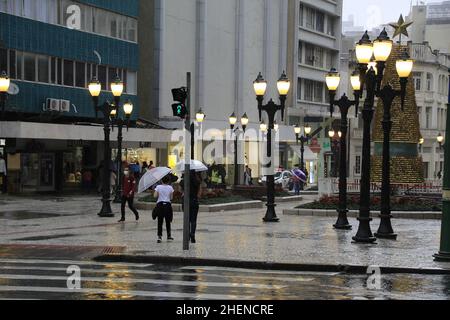 Curitiba, Parana, Brasilien. 11th Januar 2022. (INT) Regentag mit Wintergesicht in Curitiba. 11. Januar 2022, Curitiba, Parana, Brasilien: Fußgänger-Bewegung auf dem Calcadao da XV und dem Santos Andrade-Platz, in der Innenstadt von Curitiba, an einem weiteren regnerischen Tag in der Stadt, am Dienstag (11). Kälteres Wetter lässt die Stadt im Hochsommer wie Herbst aussehen. (Bild: © Edson De Souza/TheNEWS2 via ZUMA Press Wire) Stockfoto