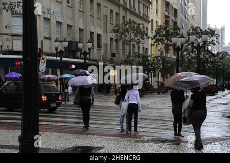 Curitiba, Parana, Brasilien. 11th Januar 2022. (INT) Regentag mit Wintergesicht in Curitiba. 11. Januar 2022, Curitiba, Parana, Brasilien: Fußgänger-Bewegung auf dem Calcadao da XV und dem Santos Andrade-Platz, in der Innenstadt von Curitiba, an einem weiteren regnerischen Tag in der Stadt, am Dienstag (11). Kälteres Wetter lässt die Stadt im Hochsommer wie Herbst aussehen. (Bild: © Edson De Souza/TheNEWS2 via ZUMA Press Wire) Stockfoto