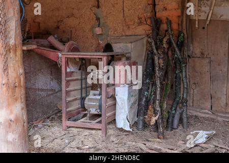 Ein Schuppen im Dorf mit einer alten Säge zum Schneiden von Holz und anderen ländlichen Gegenständen Stockfoto