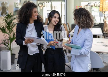 Multikulturelle Mitarbeiter, die im Büro arbeiten und ein Gespräch führen. Stockfoto