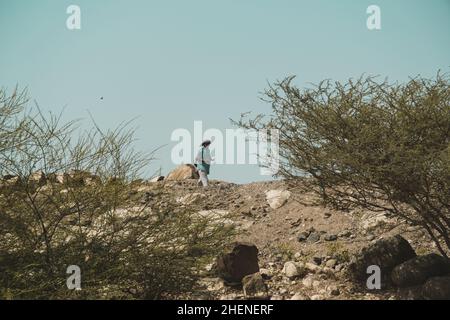 Dschibuti, Dschibuti - 21. Mai 2021: Ein Mann aus Dschibuti, der allein in der kargen Gegend unterwegs ist und betet. Redaktionelle Aufnahme in Dschibuti Stockfoto