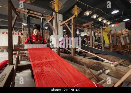 QIANDONGNAN, CHINA - 11. JANUAR 2022 - umgesiedelte Menschen weben traditionelle Miao-Bekleidungsstoffe in der südöstlichen Provinz Guizhou, China, 11. Januar 2022 Stockfoto