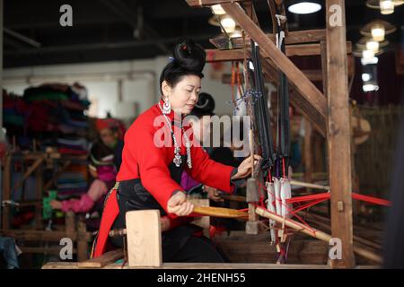 QIANDONGNAN, CHINA - 11. JANUAR 2022 - umgesiedelte Menschen weben traditionelle Miao-Bekleidungsstoffe in der südöstlichen Provinz Guizhou, China, 11. Januar 2022 Stockfoto